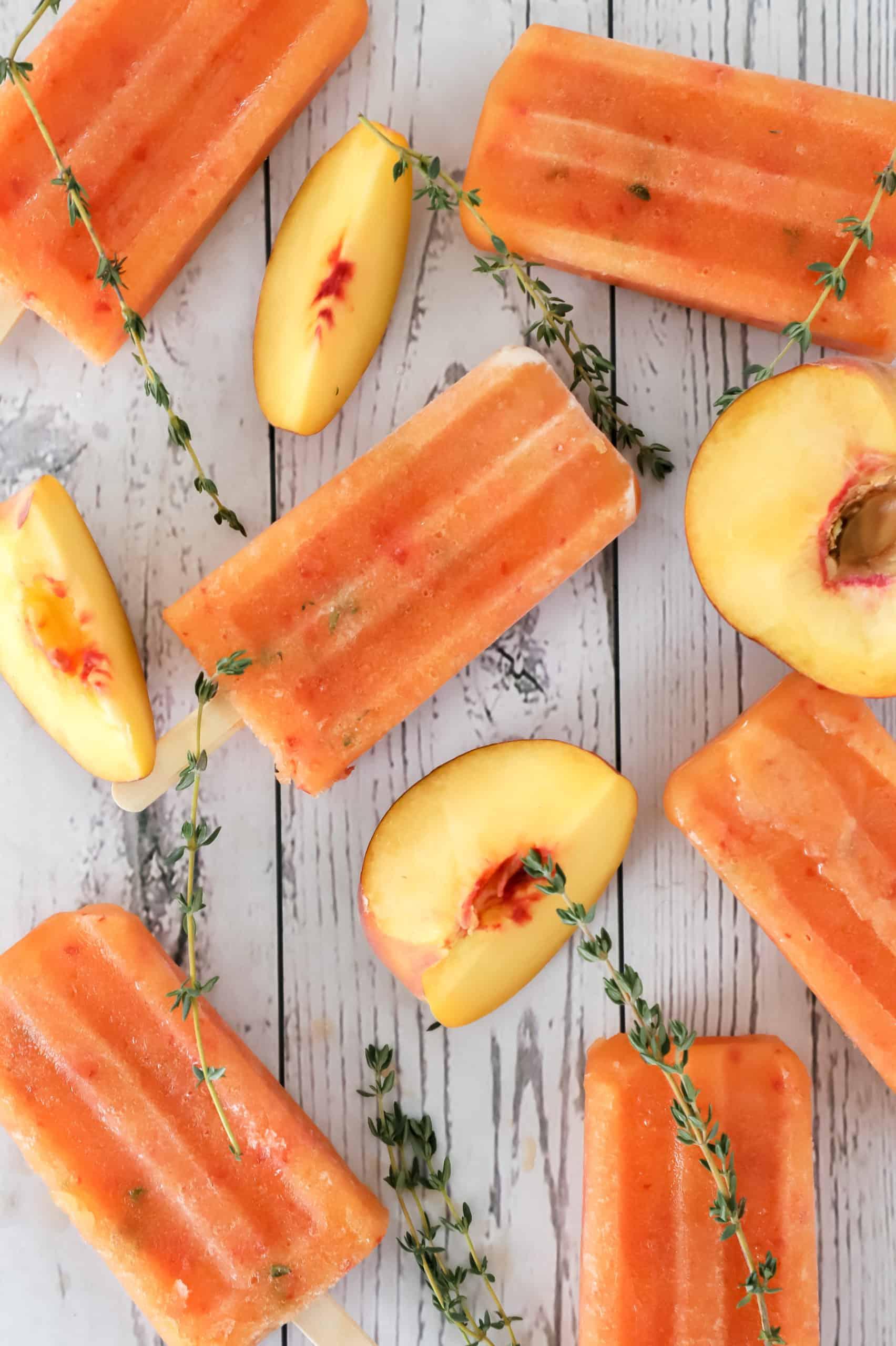 homemade peach thyme popsicles on a wooden surface
