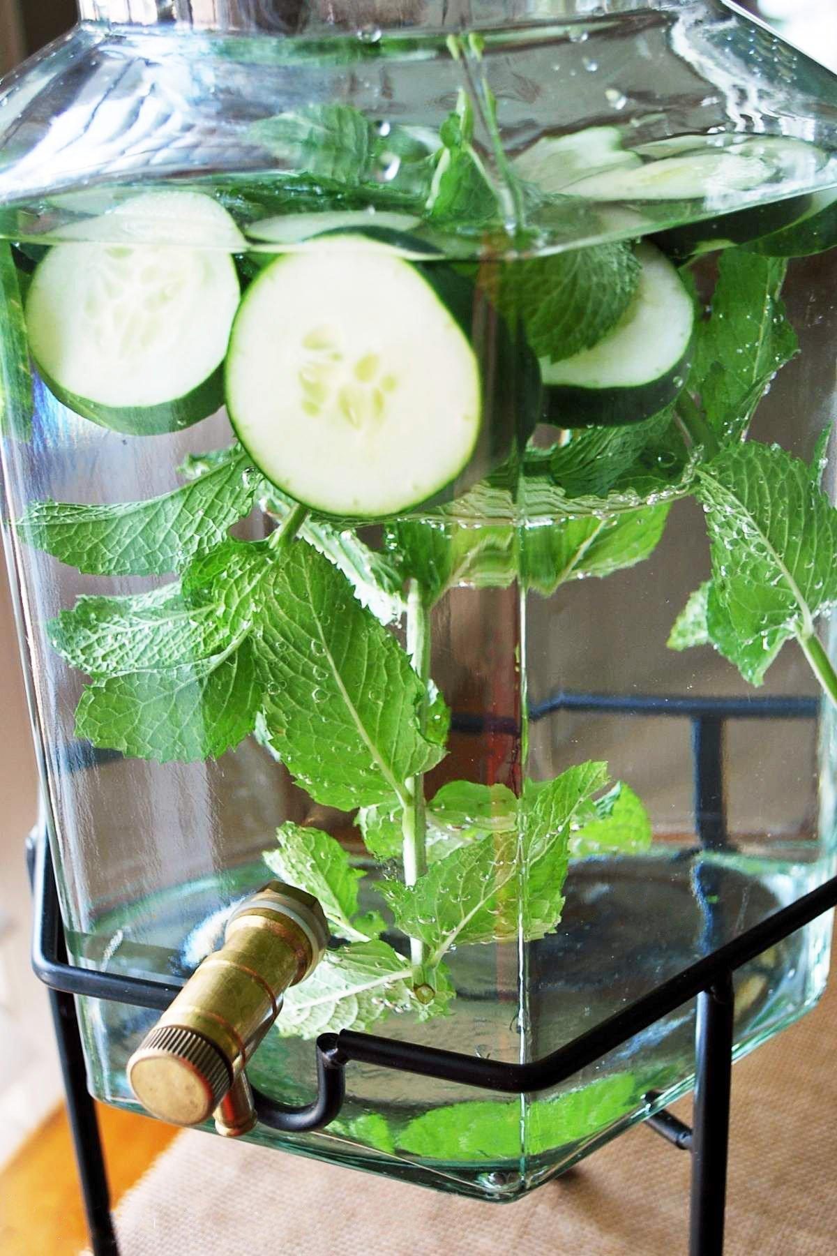 person preparing cucumber mint infused water in a kitchen