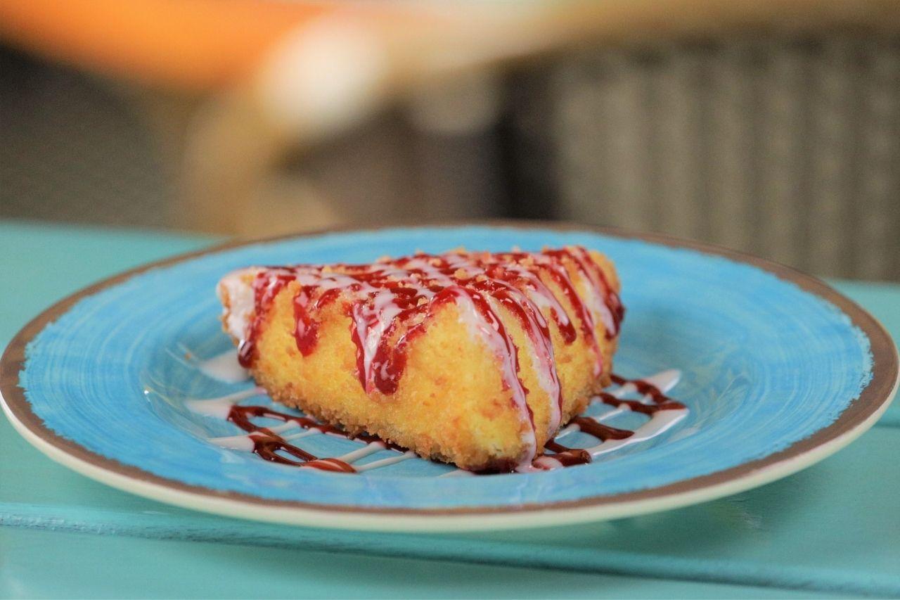 Key lime pie spring rolls being deep fried in oil
