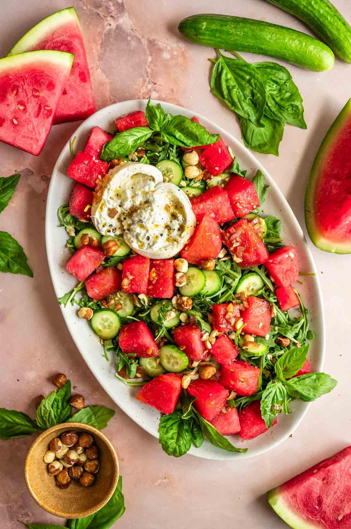 Close-up shot of watermelon and mozzarella salad with mint pesto being assembled.