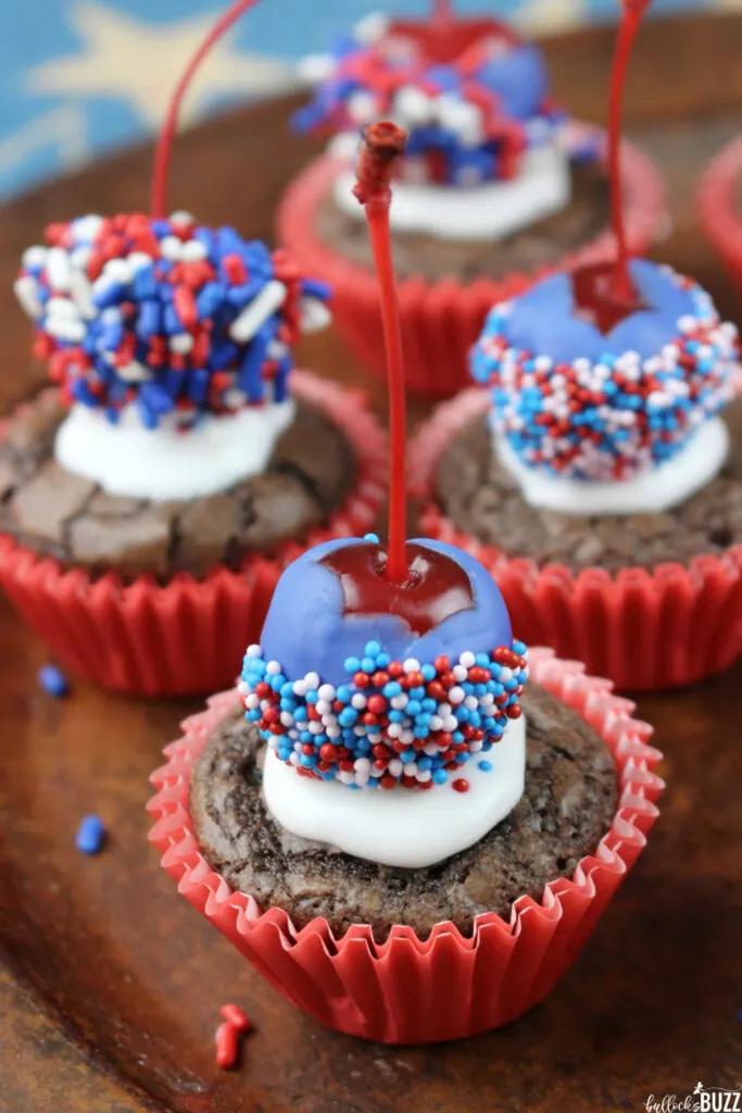 close-up of a child decorating brownie bites with red white and blue sprinkles