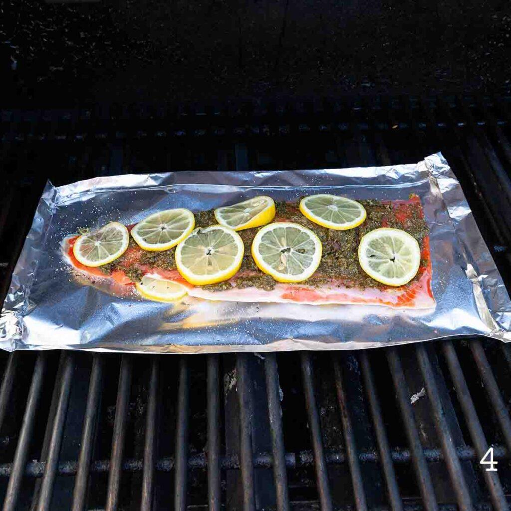 pesto-crusted salmon grilling on a barbecue