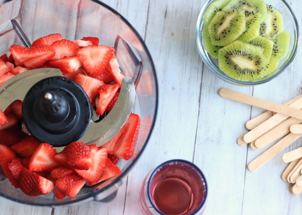 Popsicle molds filled with blended kiwi, strawberry, and mint mixture