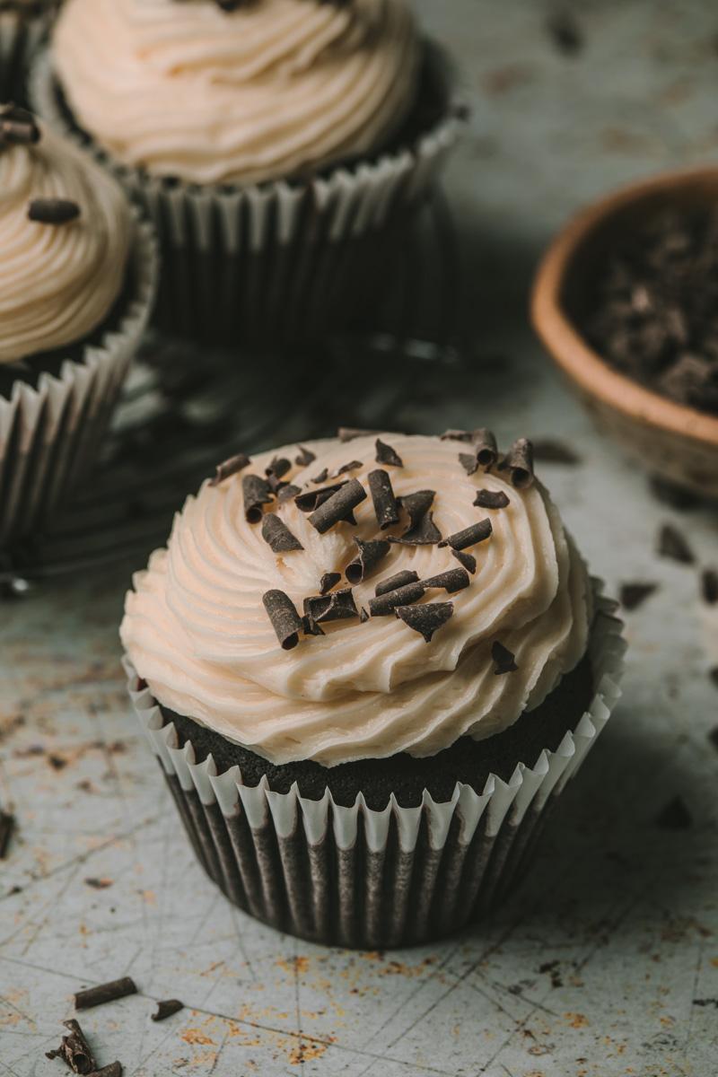 mini Irish cream cupcakes topped with frosting and a sprinkle of cocoa powder