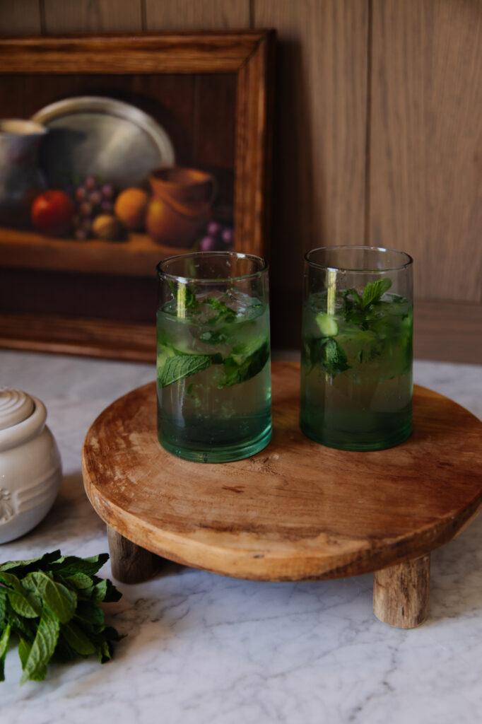 Ingredients for cucumber mint mojito mocktail on a wooden surface