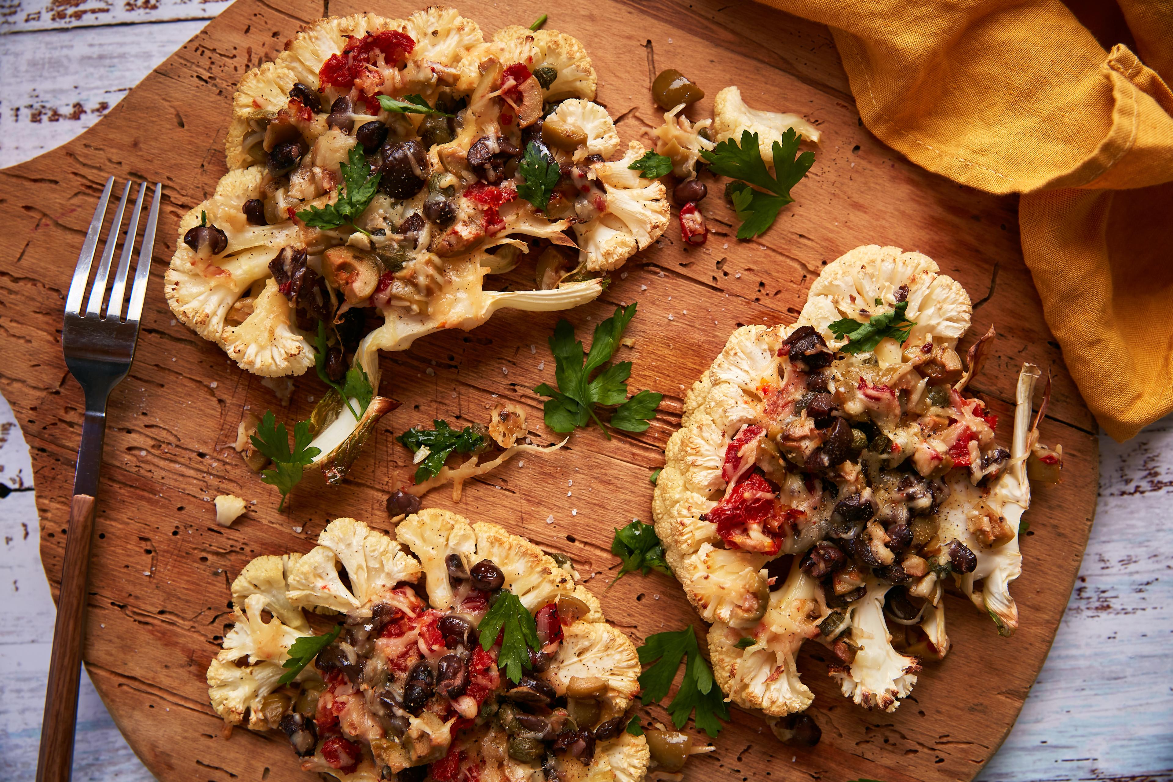 overhead shot of cauliflower steaks with black bean and corn salad on a rustic wooden table
