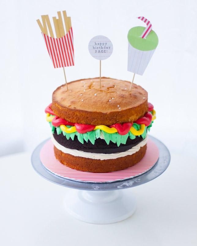 Burger cake with layers of chocolate and vanilla, decorated with fondant toppings, studio lighting