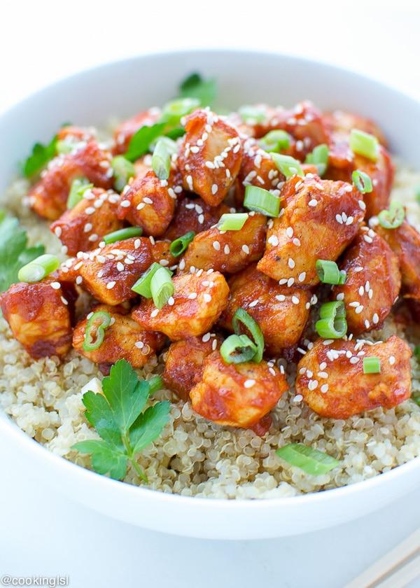 A person enjoying a sriracha chicken quinoa bowl with a fork