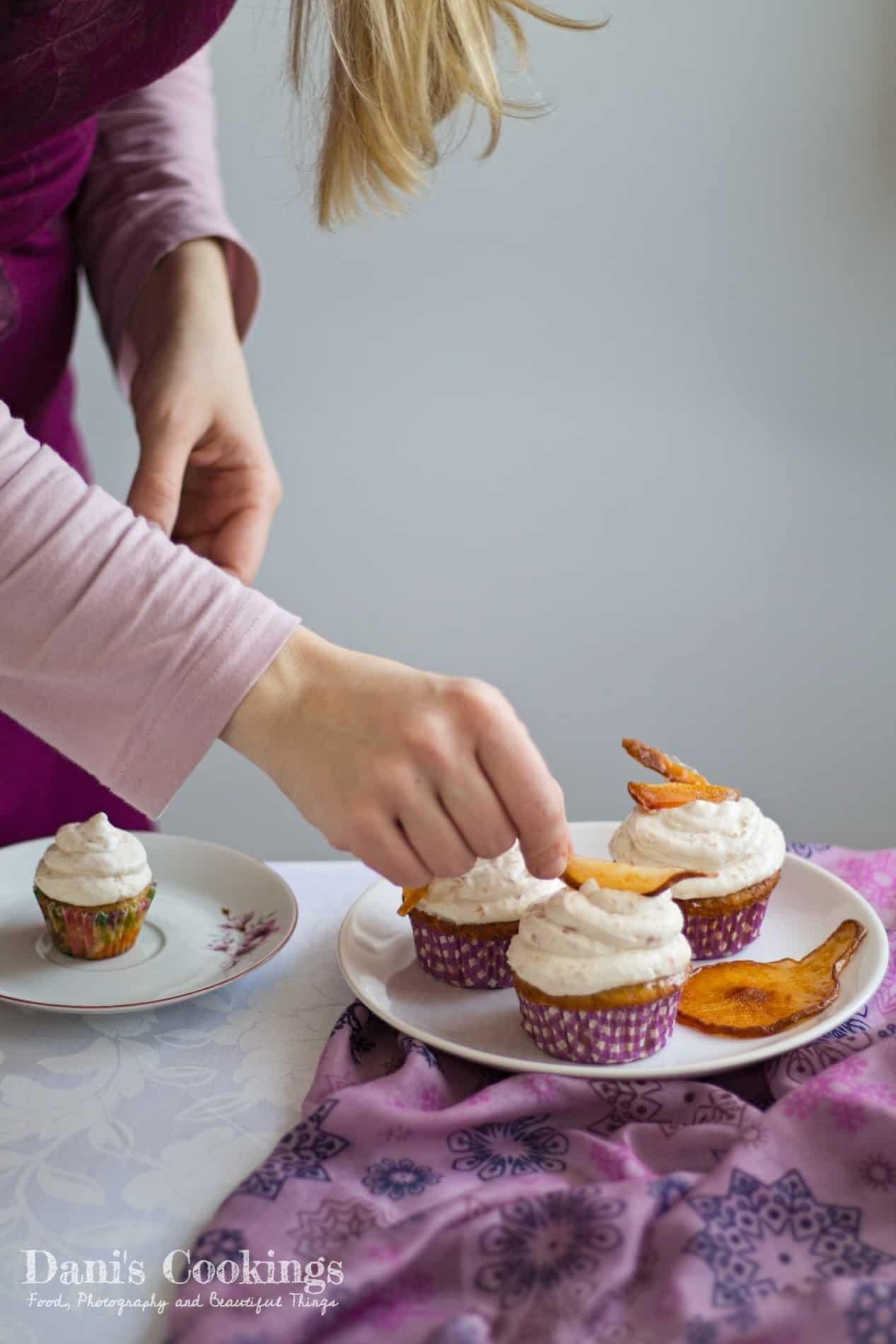 a person frosting pear ginger mini-cupcakes with a piping bag