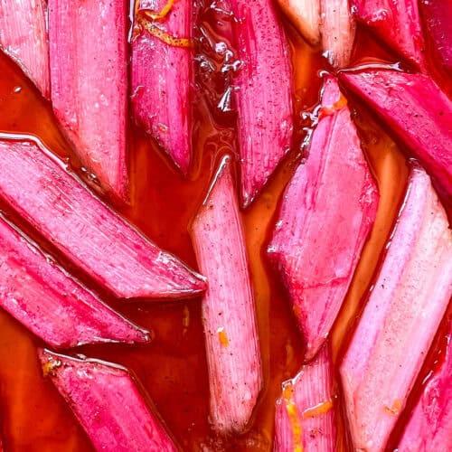 close up of fresh rhubarb stalks with maple syrup drizzled on them