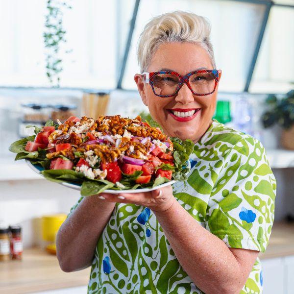 woman smiling holding a bowl of strawberry feta salad