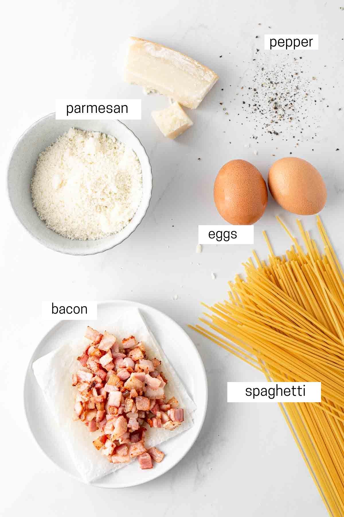 Ingredients for Spaghetti Carbonara laid out on a wooden table