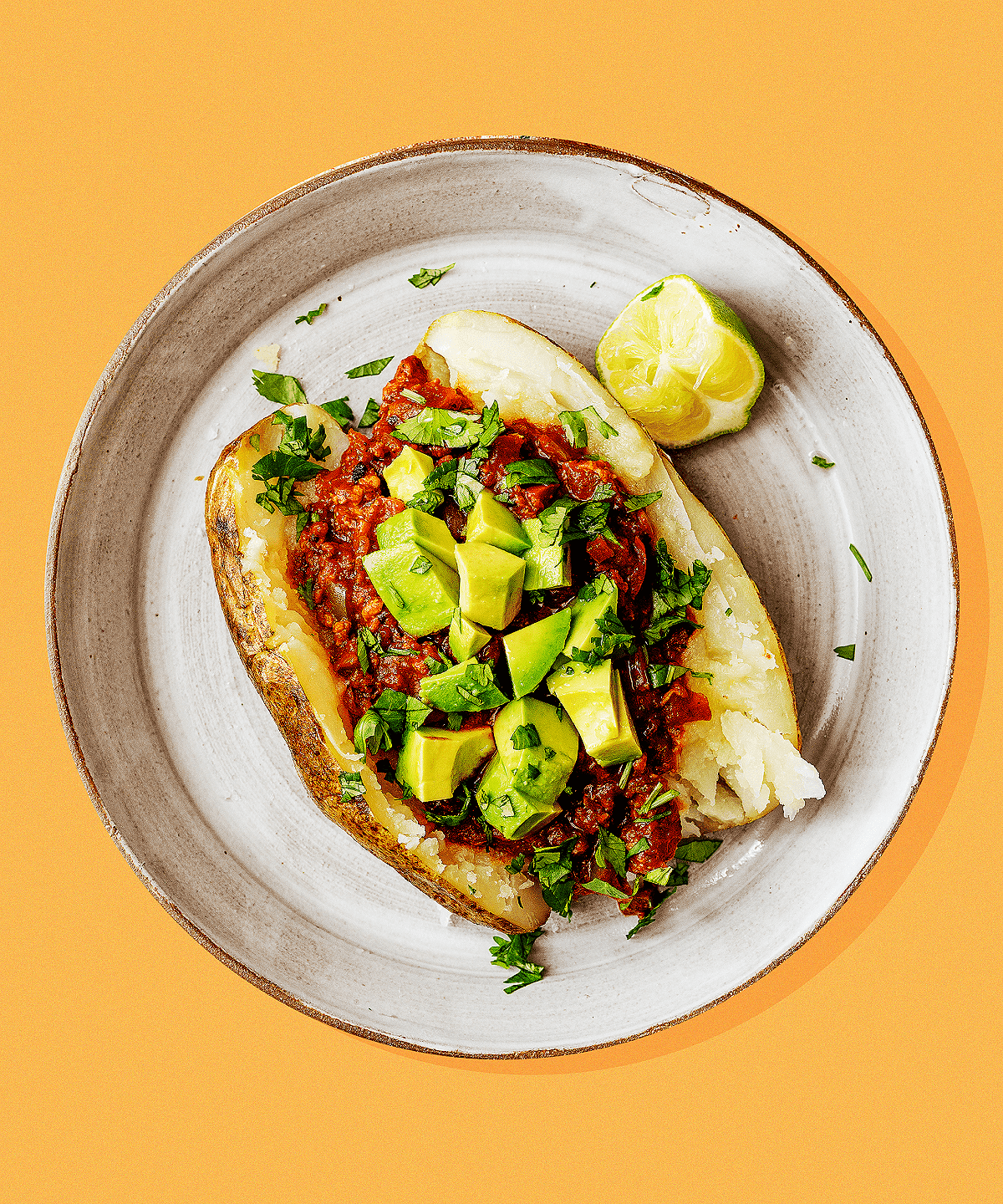 vegan chili baked potato topped with avocado