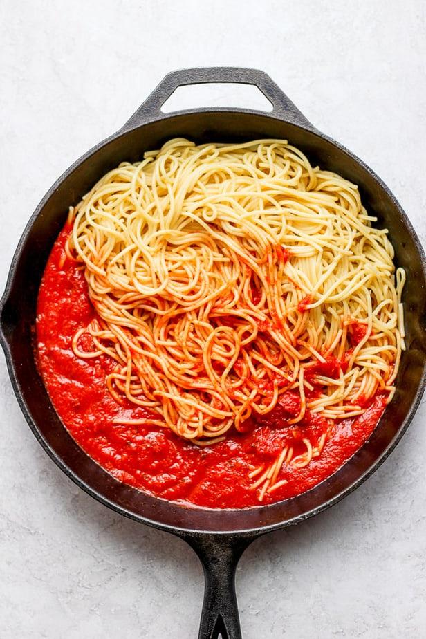 Spaghetti being cooked in a large pot on a stovetop