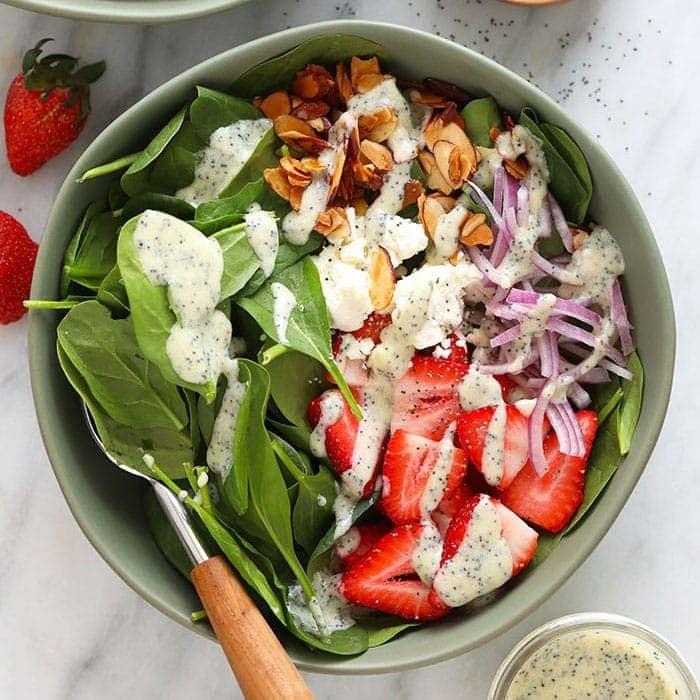 strawberry salad with poppy seed dressing in meal prep containers