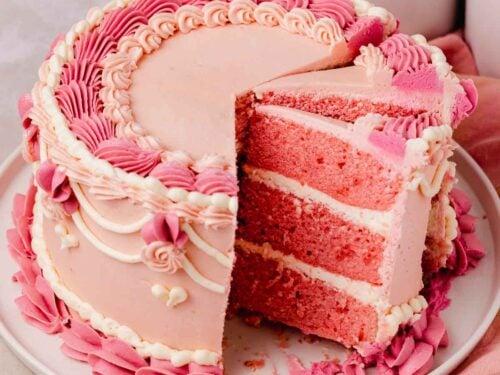 overhead view of a baker frosting the velvet aurora cake with colorful swirls, using a piping bag