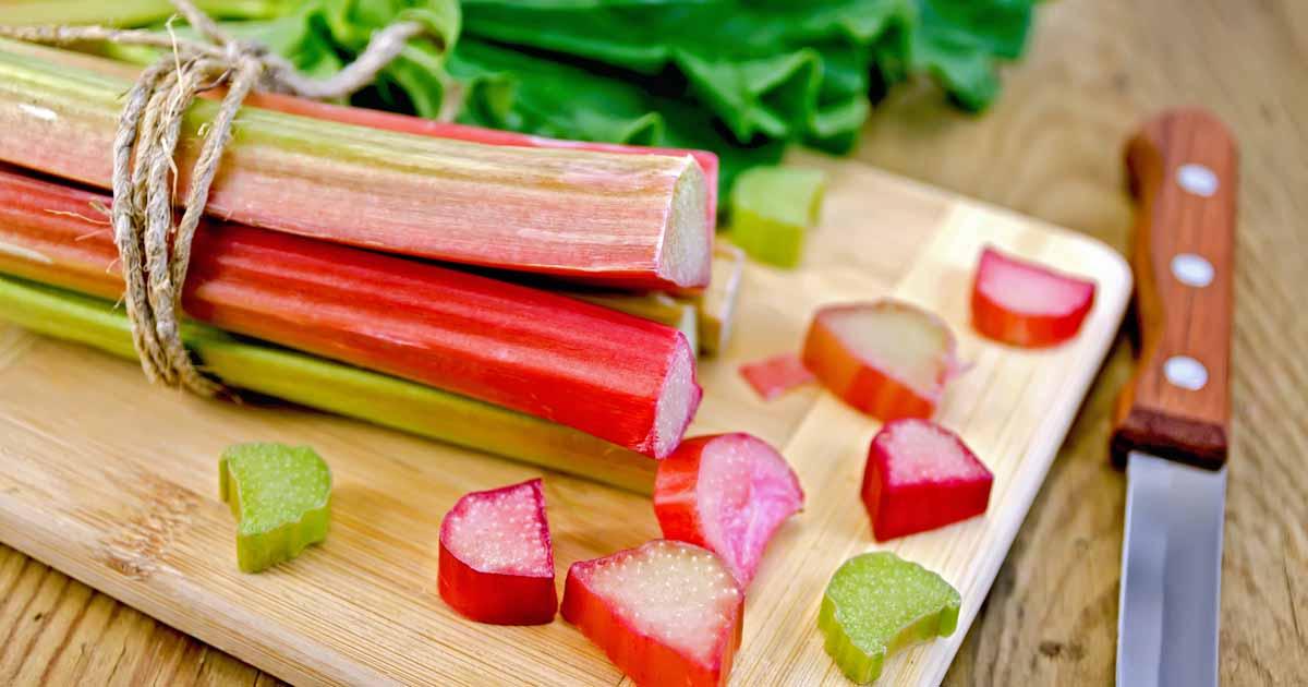A close up of rhubarb stalks on a cutting board