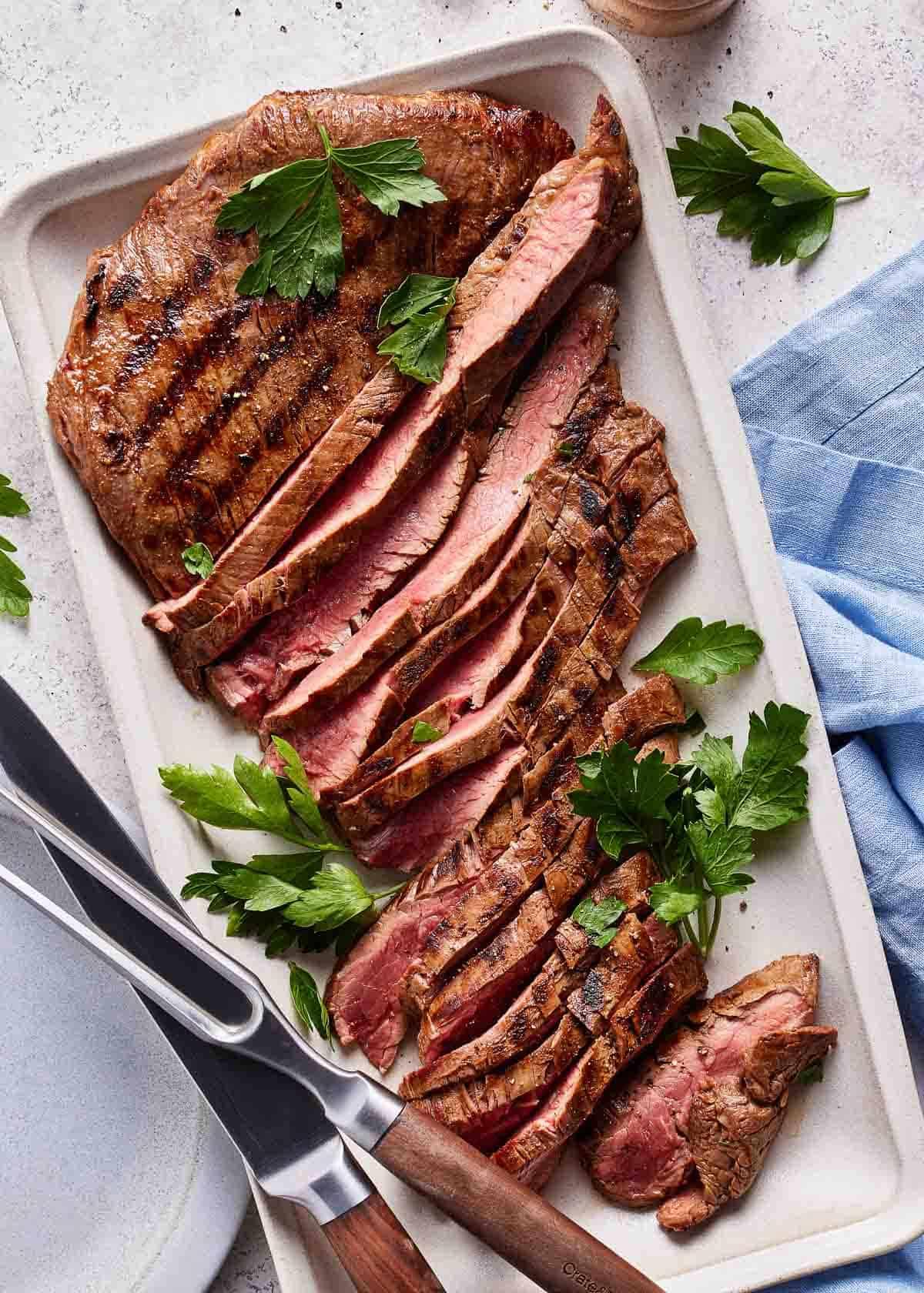 flank steak being grilled after marinating in smoked paprika marinade