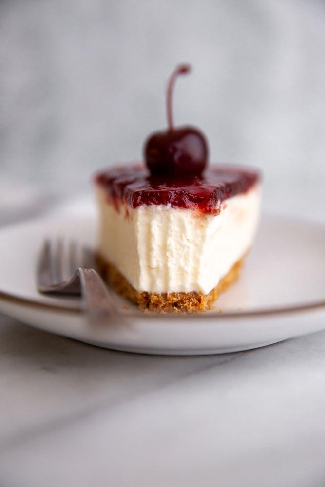Close-up shot of a slice of Italian Mascarpone Cheesecake being lifted from the rest of the cheesecake