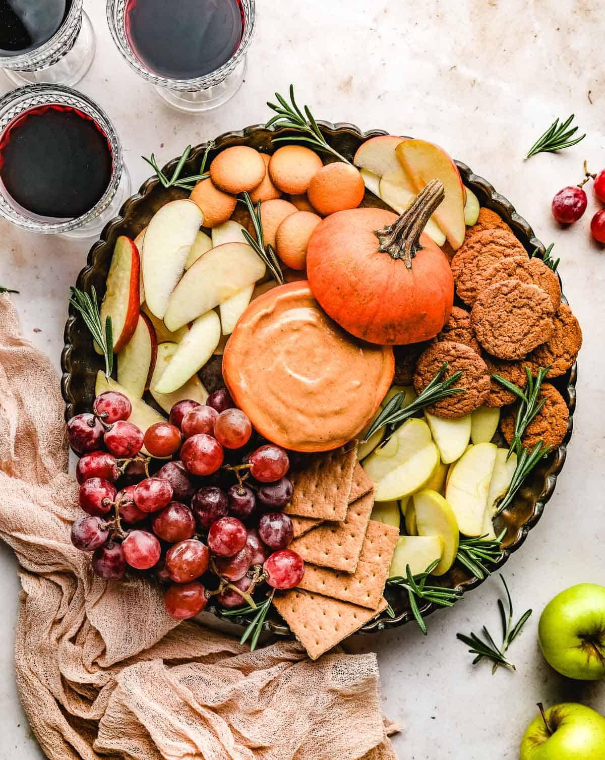 overhead shot of a table with sugar-free pumpkin cheesecake dip, apple slices, and gingerbread cookies