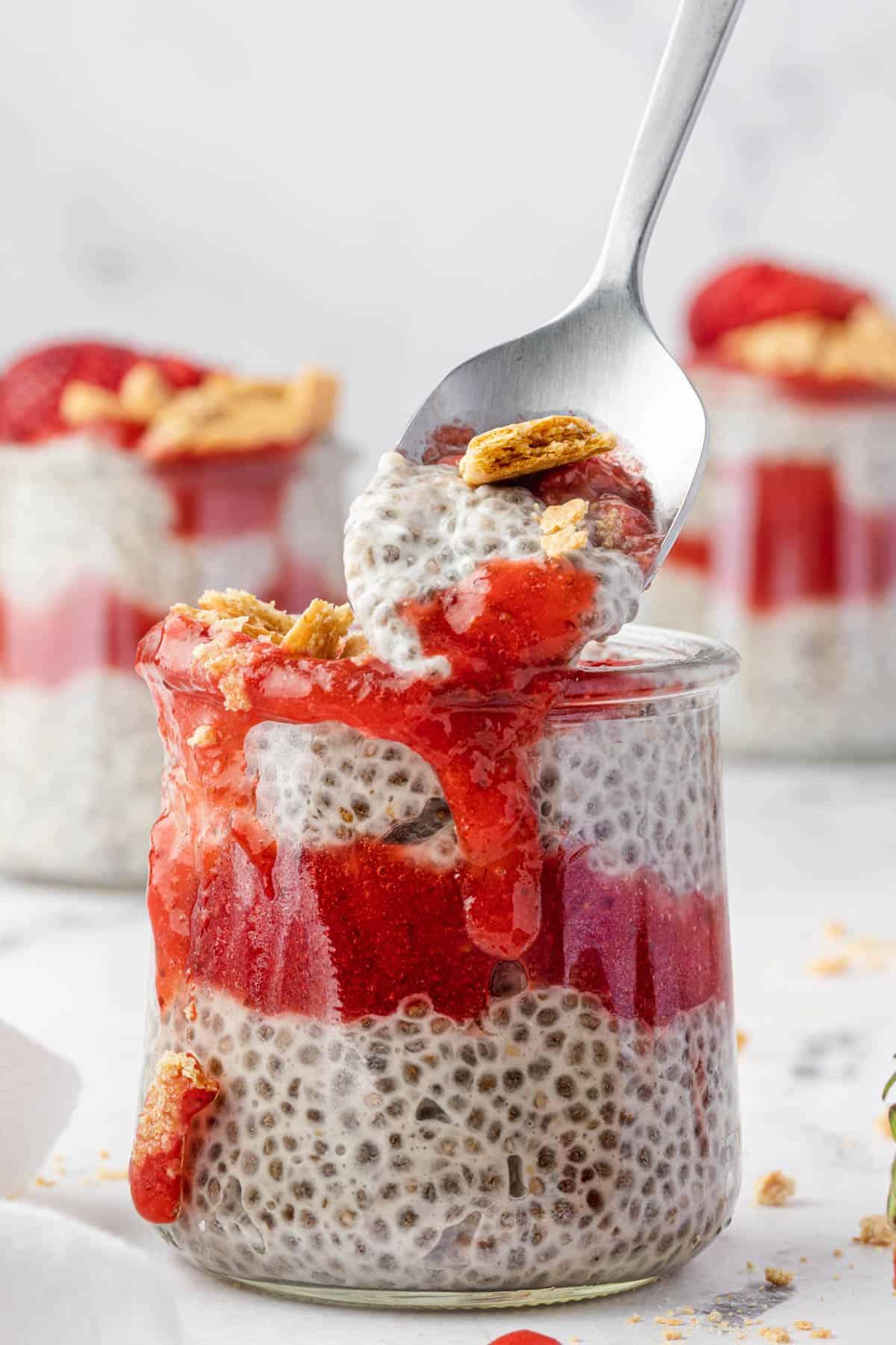 close up of layered strawberry shortcake chia pudding in a glass jar
