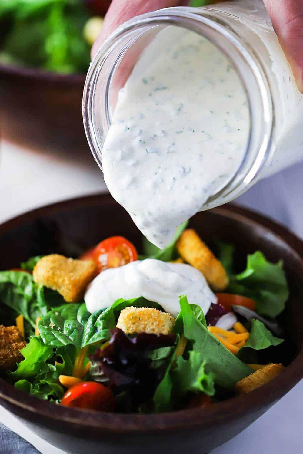 pouring homemade ranch dressing over grilled lettuce
