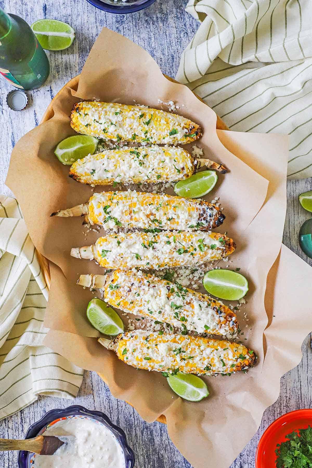 overhead shot of several grilled corn cobs with crema and cilantro