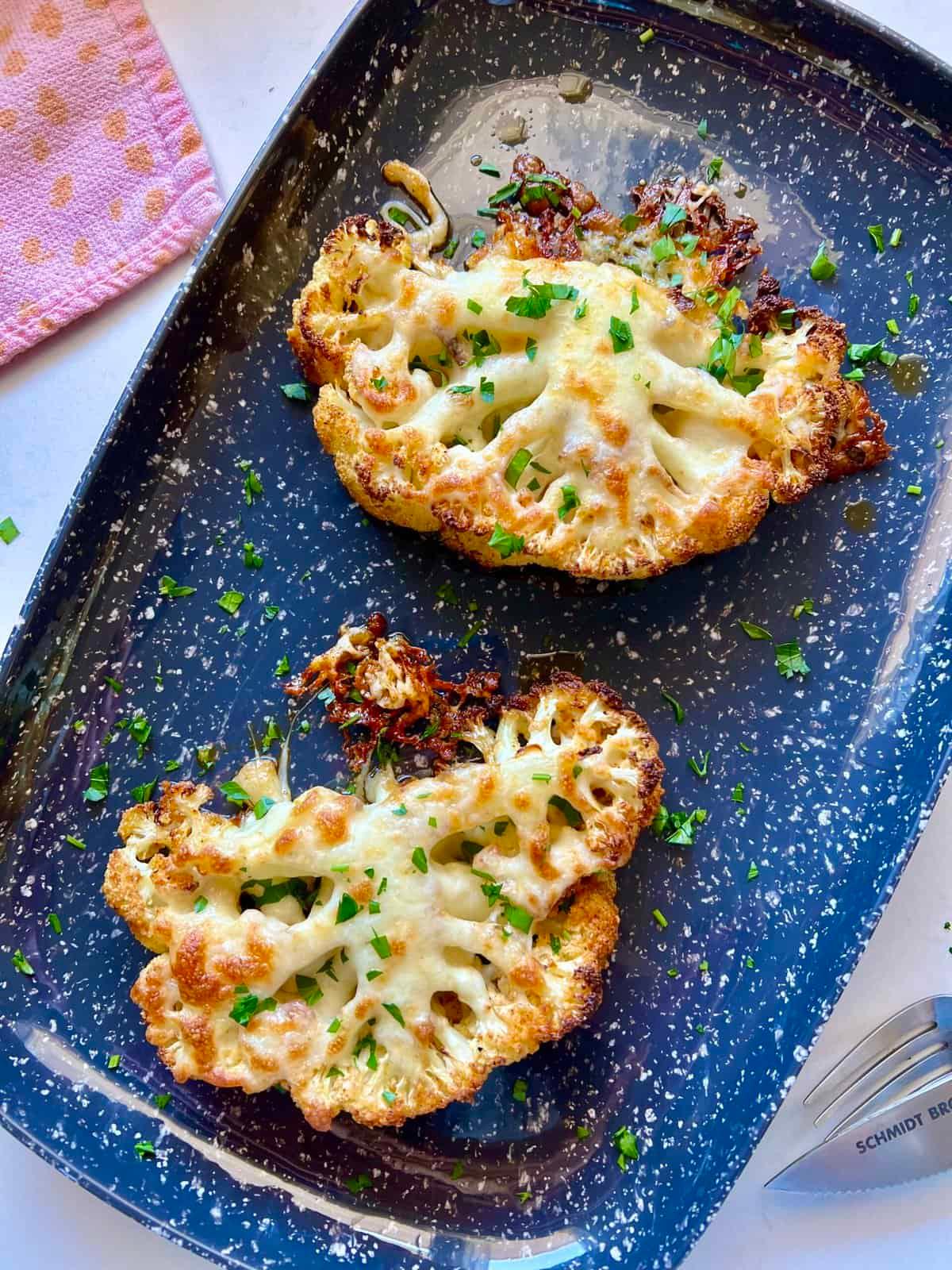 cauliflower steaks topped with melted maasdam cheese and sliced pears on a plate