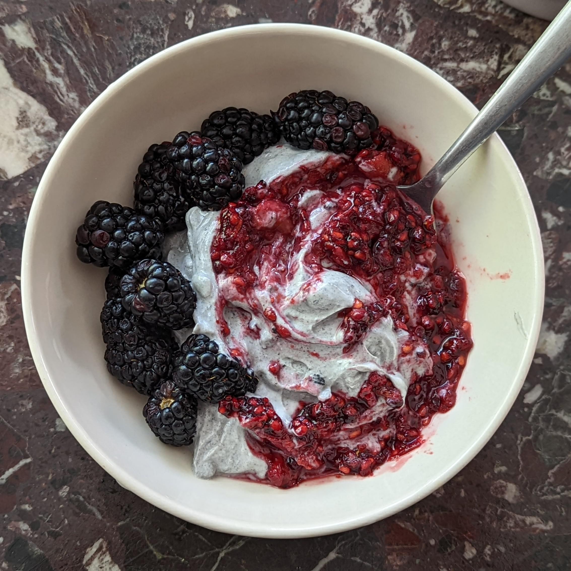 close up shot of a bowl of frozen black sesame lavender yogurt with fresh lavender sprigs