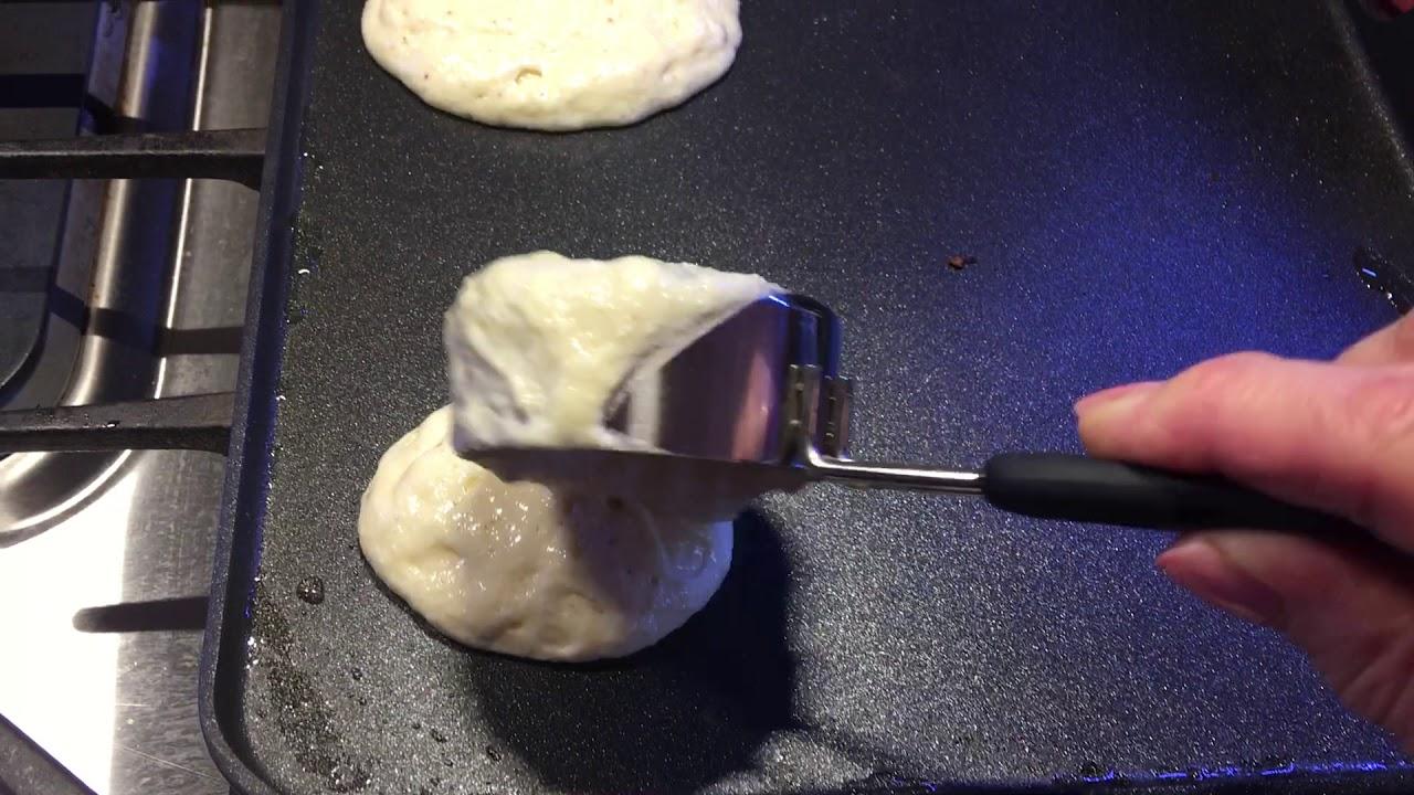 person pouring pancake batter onto a griddle