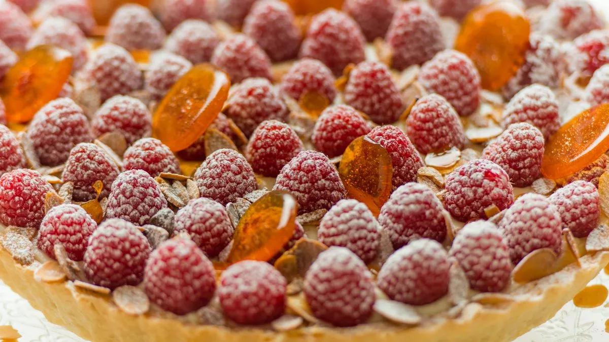 overhead shot of ingredients for lychee rose tart, including lychees, rosewater, and tart crust