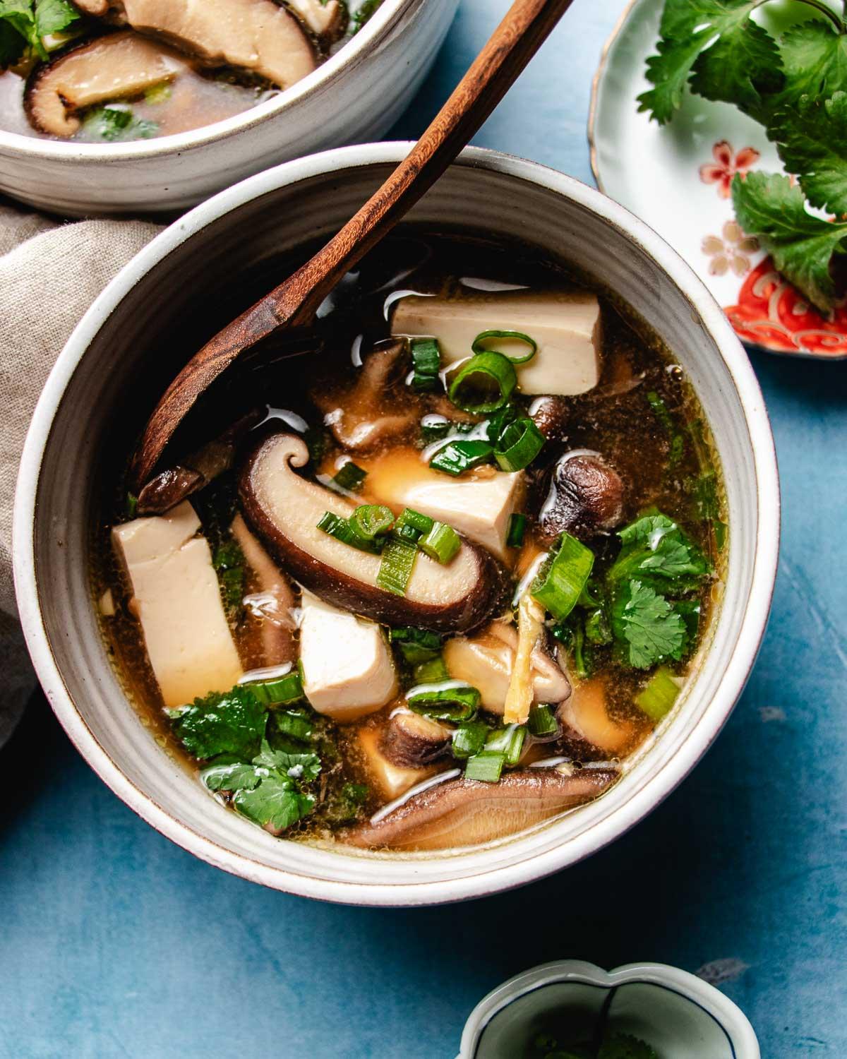 Black pepper tofu and shiitake mushroom bowl on a wooden table