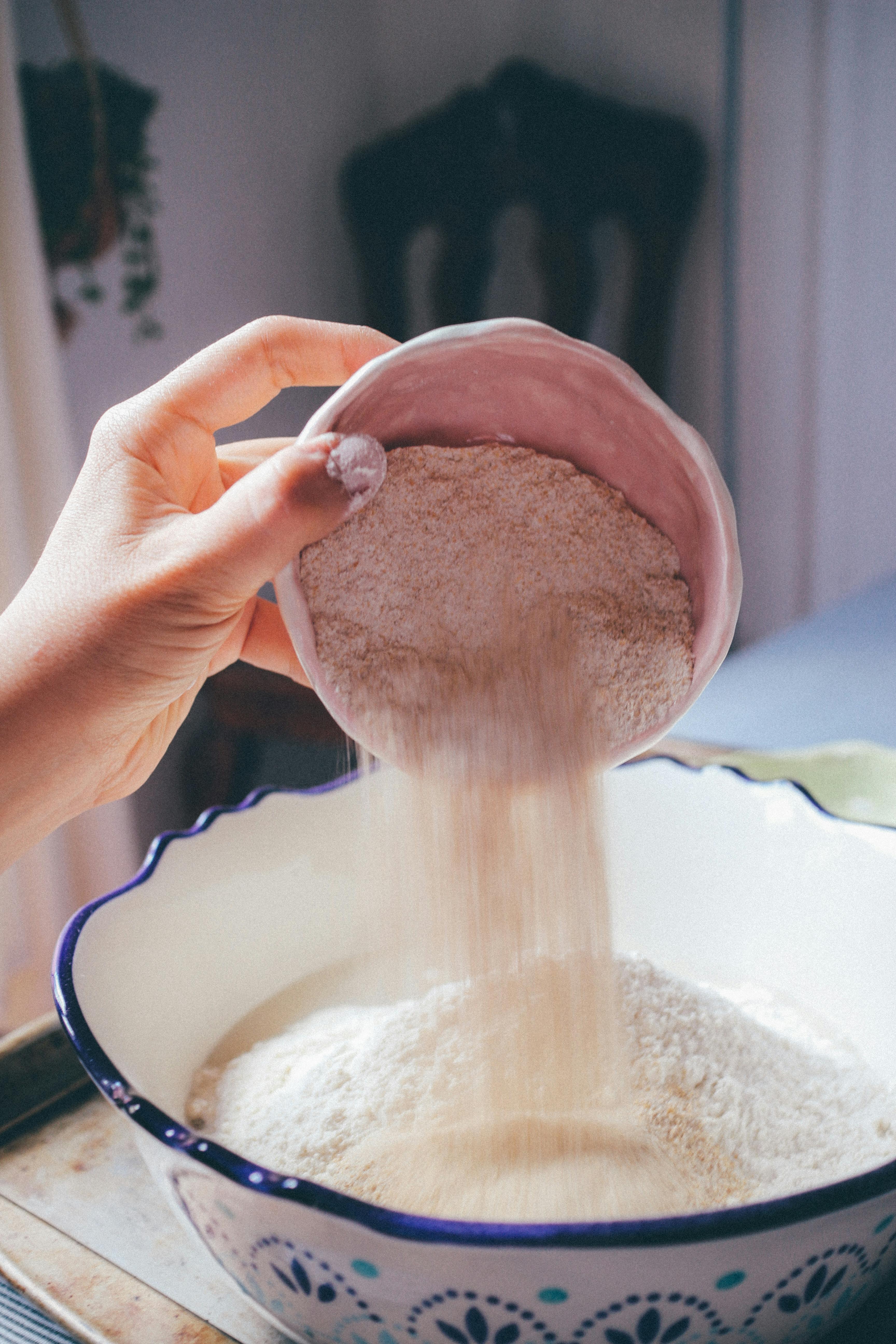close-up shot of sorghum flour being poured into a mixing bowl