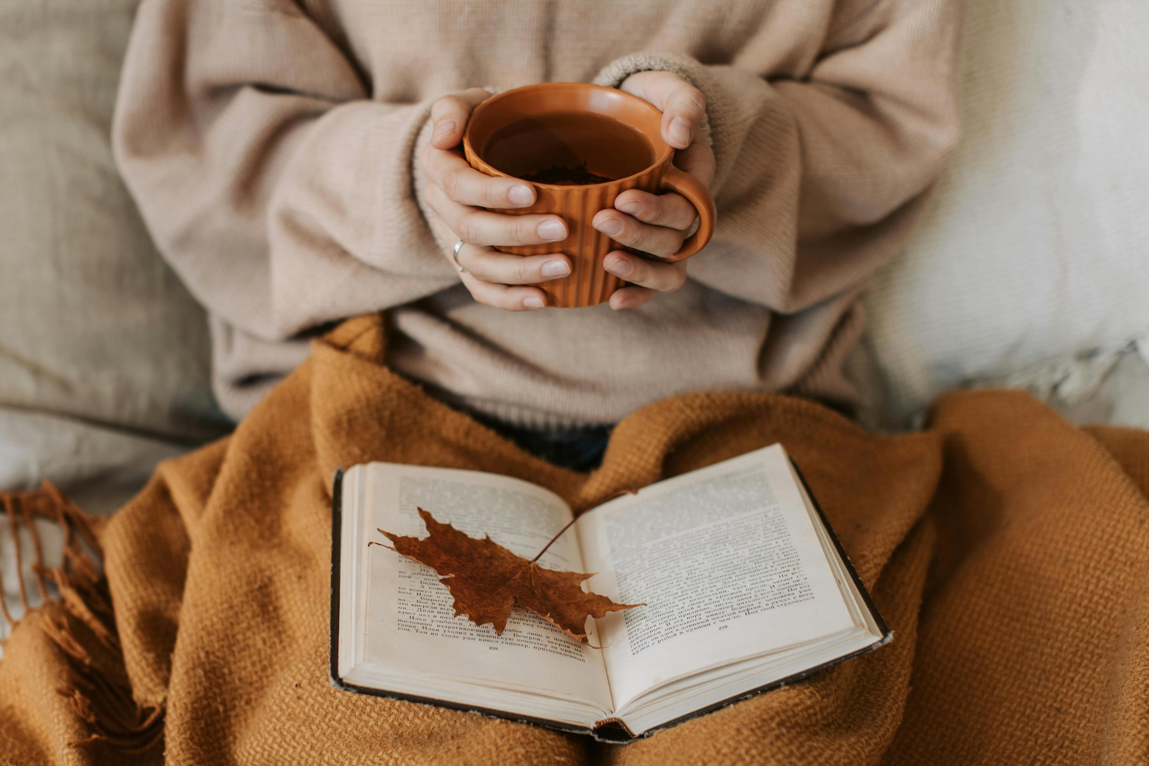cozy tea shop interior with a person holding a mug of tea
