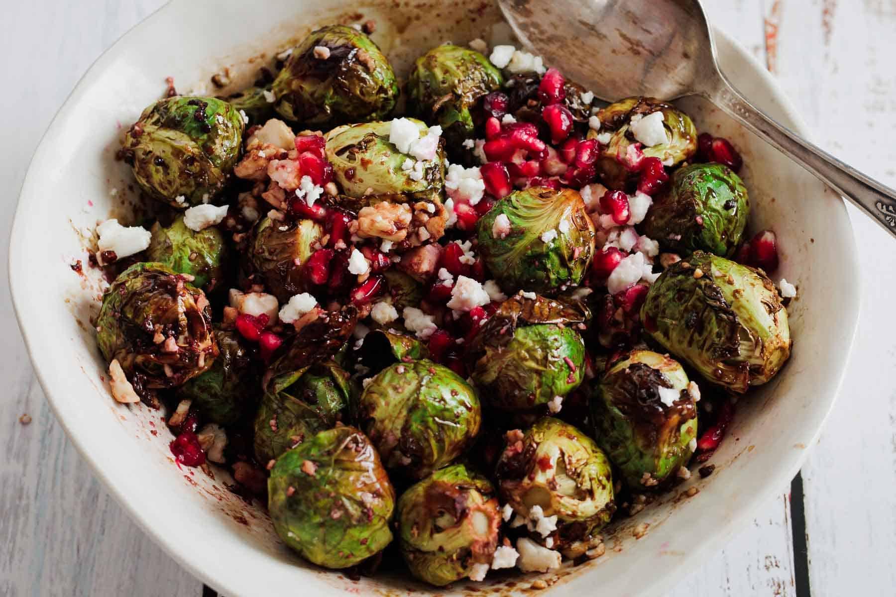 close up of roasted brussels sprouts with pomegranate seeds and feta
