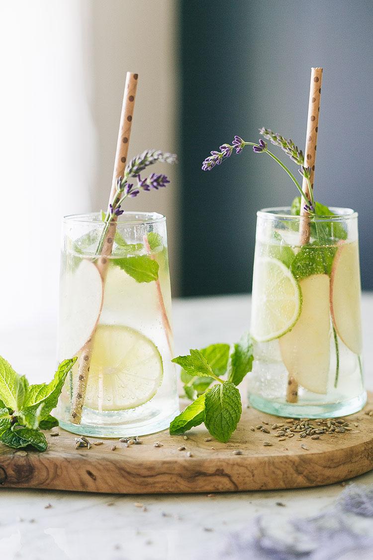close-up shot of a Lavender Lemon Virgin Mojito being mixed with a spoon, showcasing the layers of ingredients