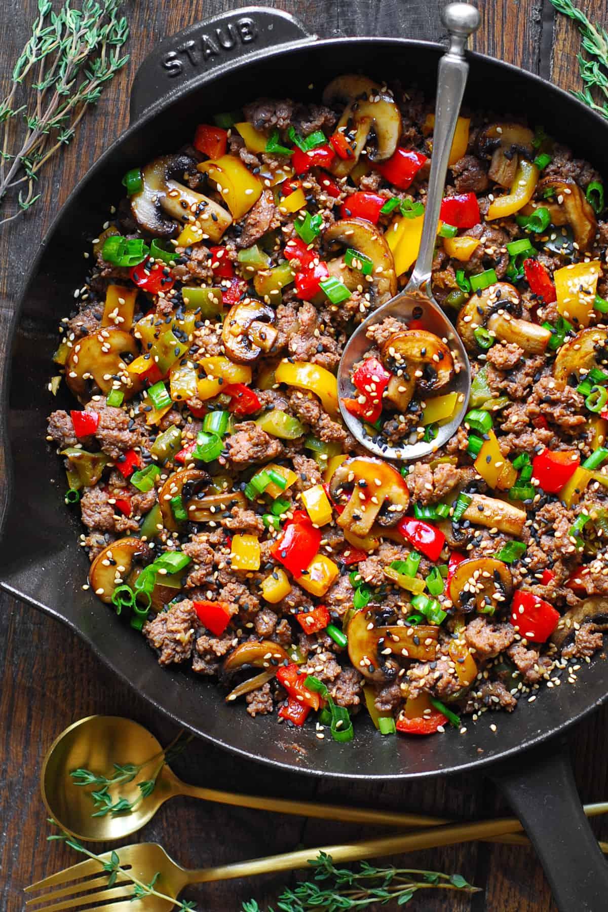 ground beef cooking in a skillet with onions and peppers