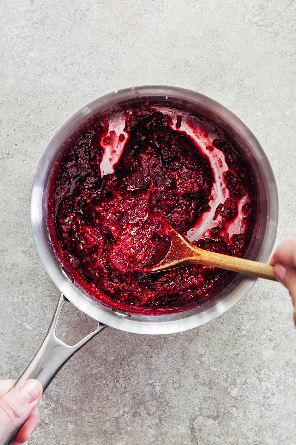 cranberry rhubarb jam being stirred in a pot