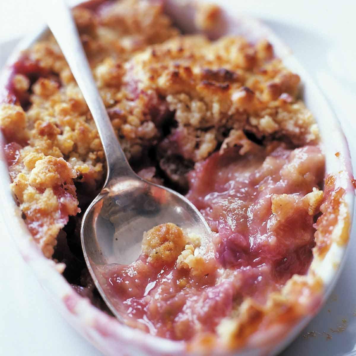close-up of rhubarb walnut dessert being served with a spoon