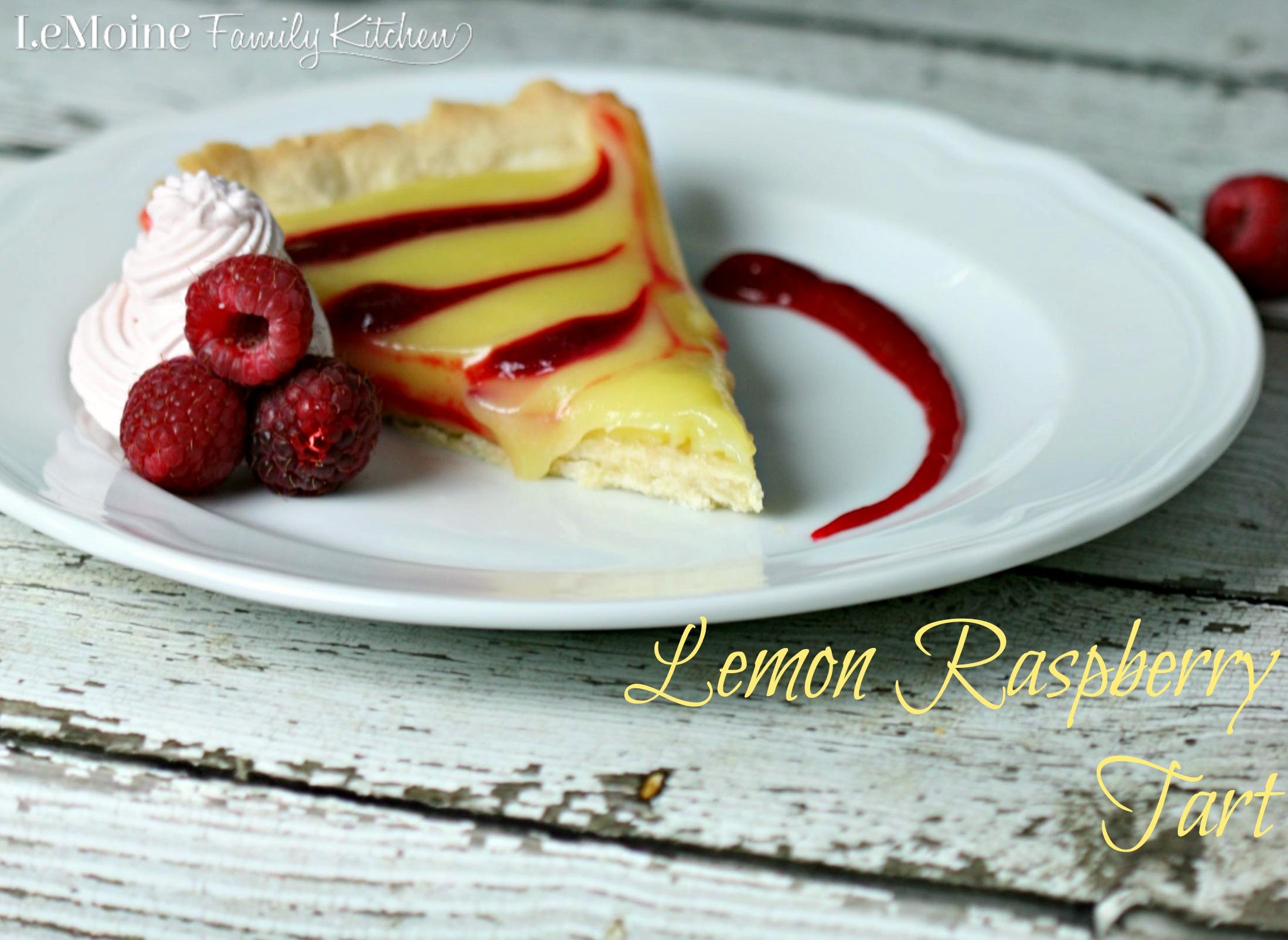 a slice of lemon curd raspberry tart on a plate, with fresh raspberries scattered around