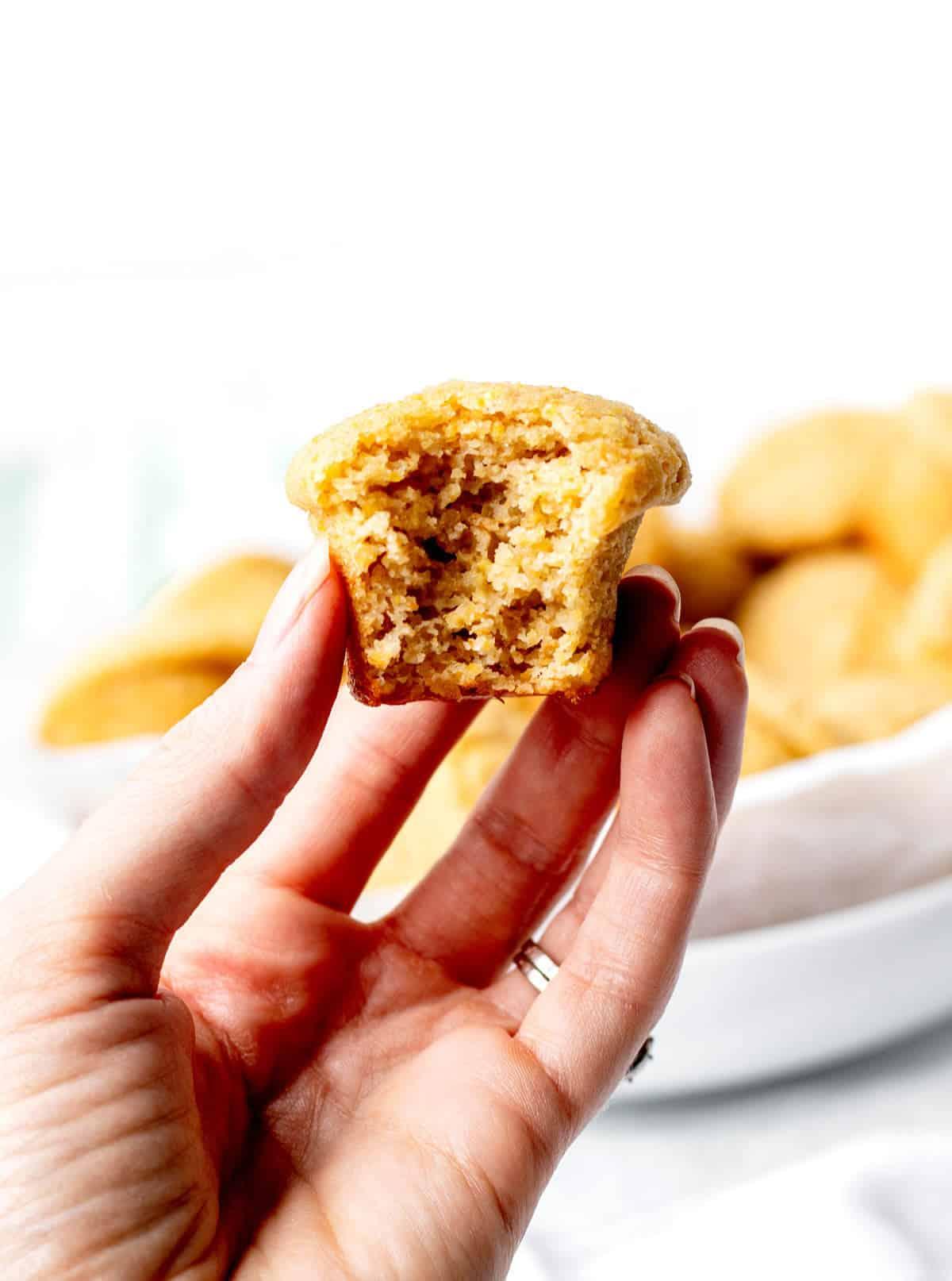 a hand drizzling honey over freshly baked mini cornbread muffins