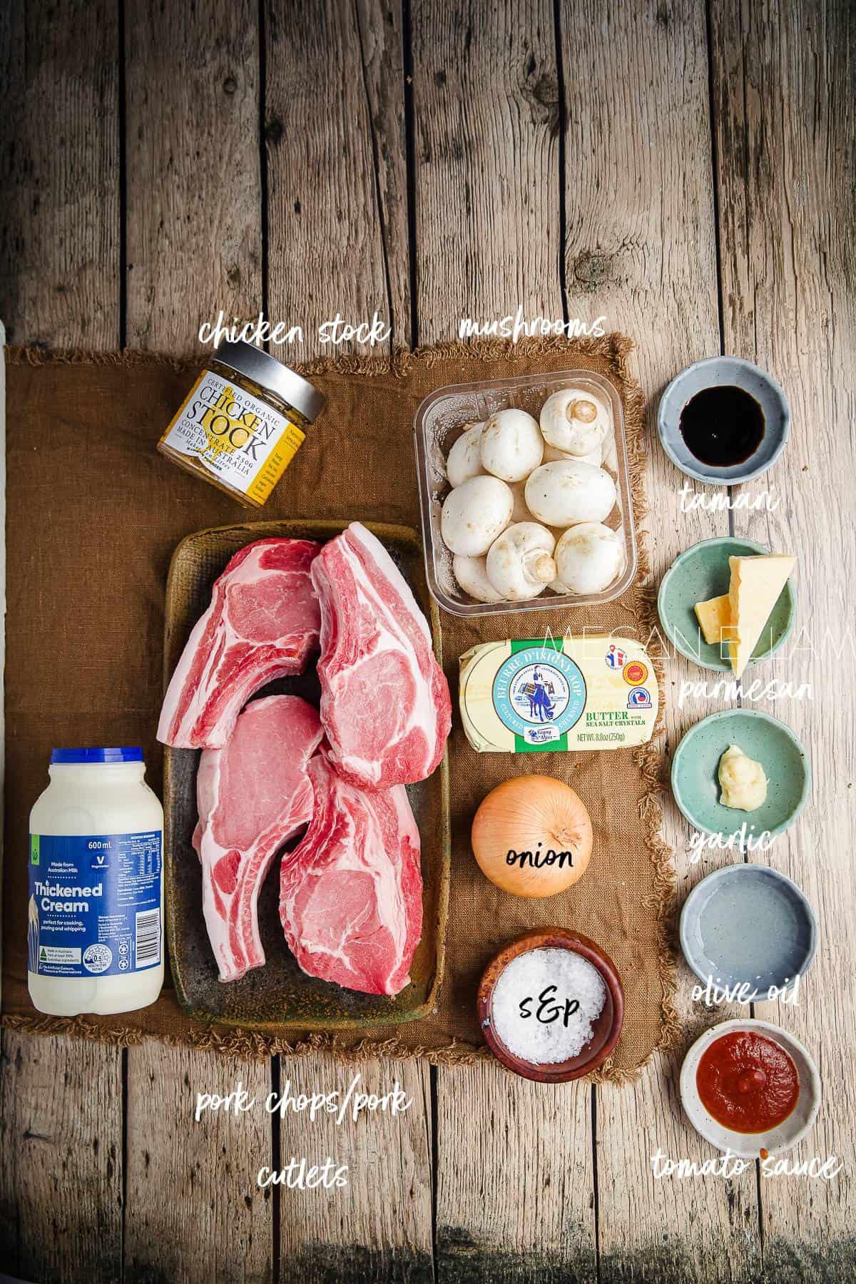 Ingredients for black garlic pork chops laid out on a wooden table.