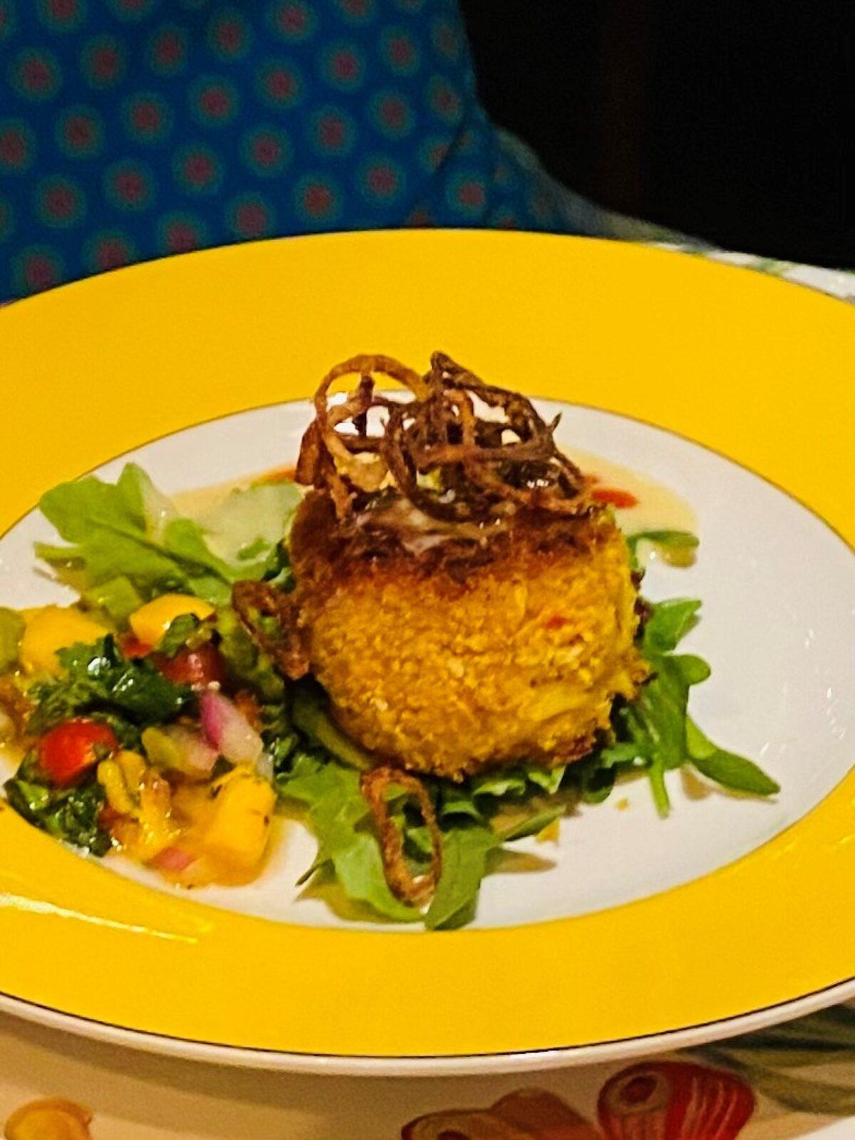 Panang curry crab cakes topped with mango salsa on a white plate