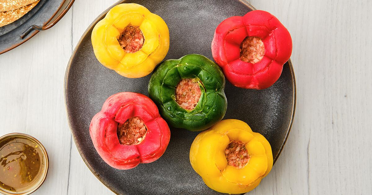 Overhead view of colorful stuffed bell peppers on a baking sheet