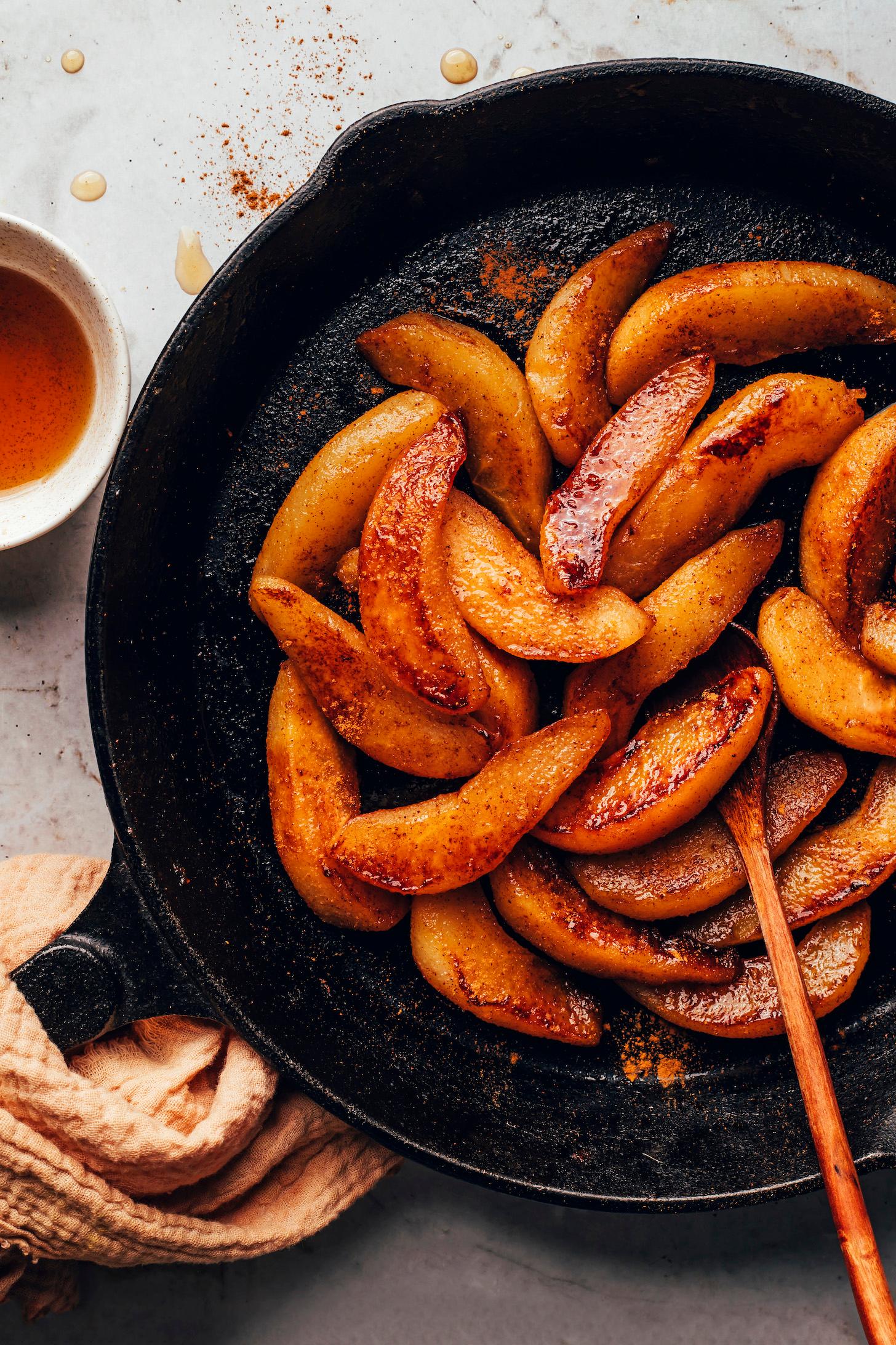 Overhead shot of spiced pears being caramelized in a pan with ginger