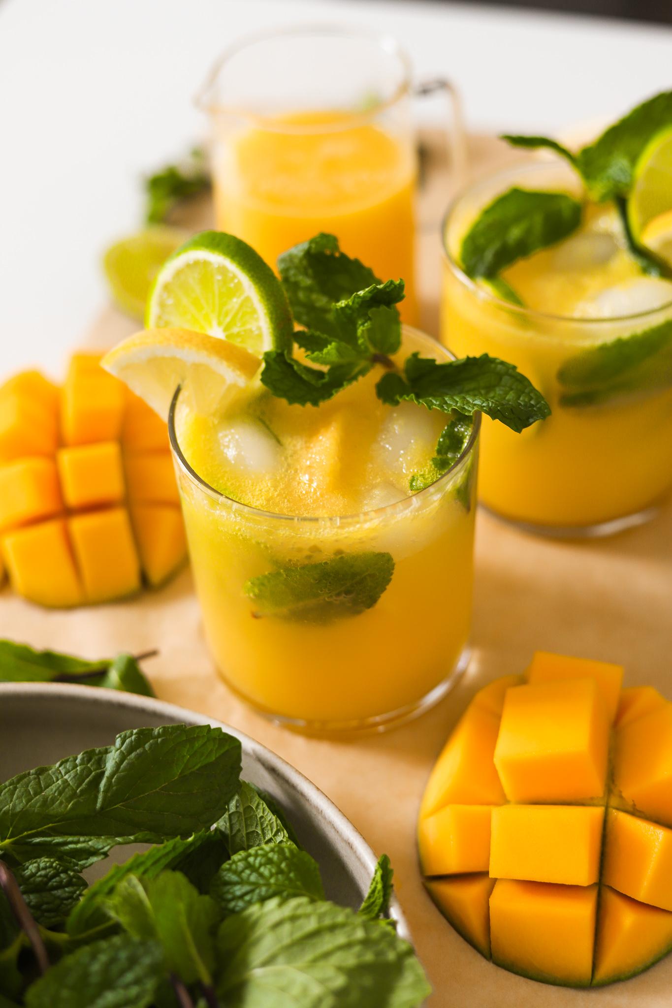 Close-up of a glass of Marjoram Mango Virgin Mojito garnished with mint and mango