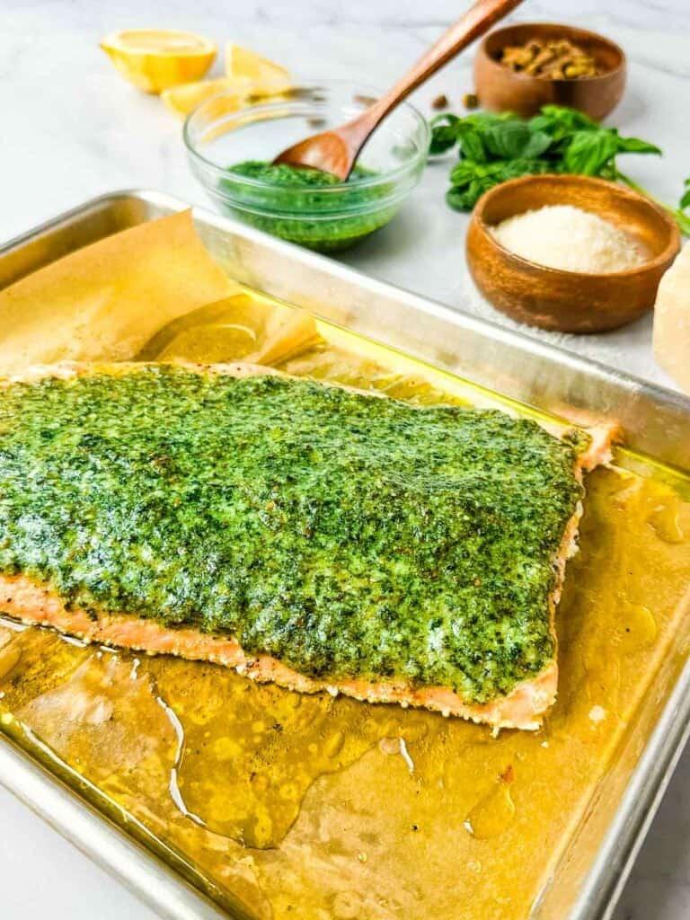 fresh salmon fillet being brushed with pesto