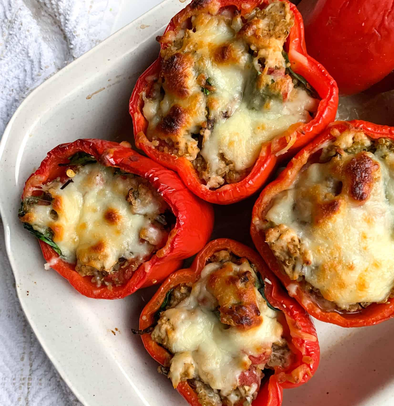 Close-up shot of bell peppers being stuffed with chicken and pesto filling