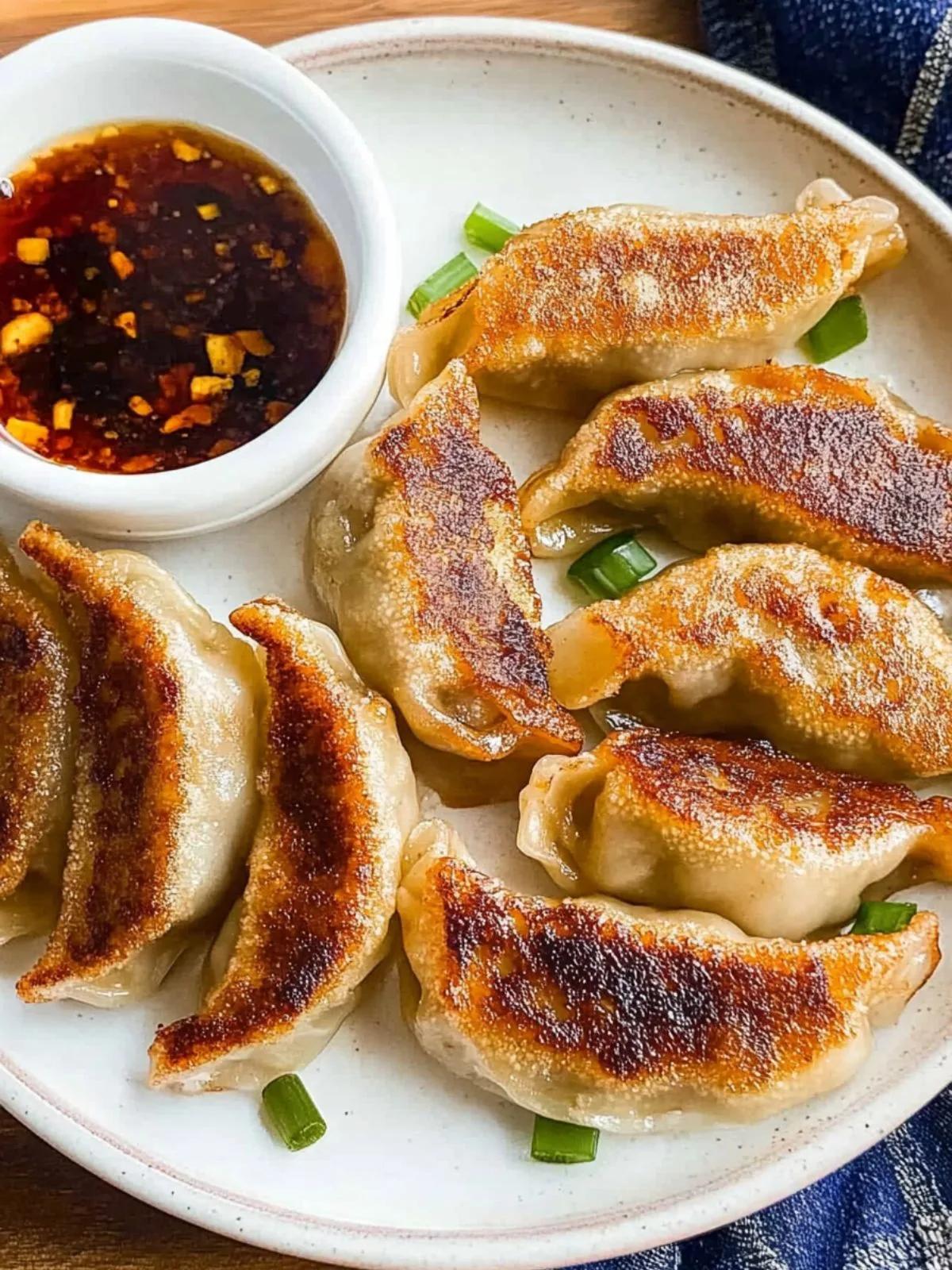 close up shot of pulled pork potstickers with soy ginger glaze drizzled on top, garnished with green onions and sesame seeds