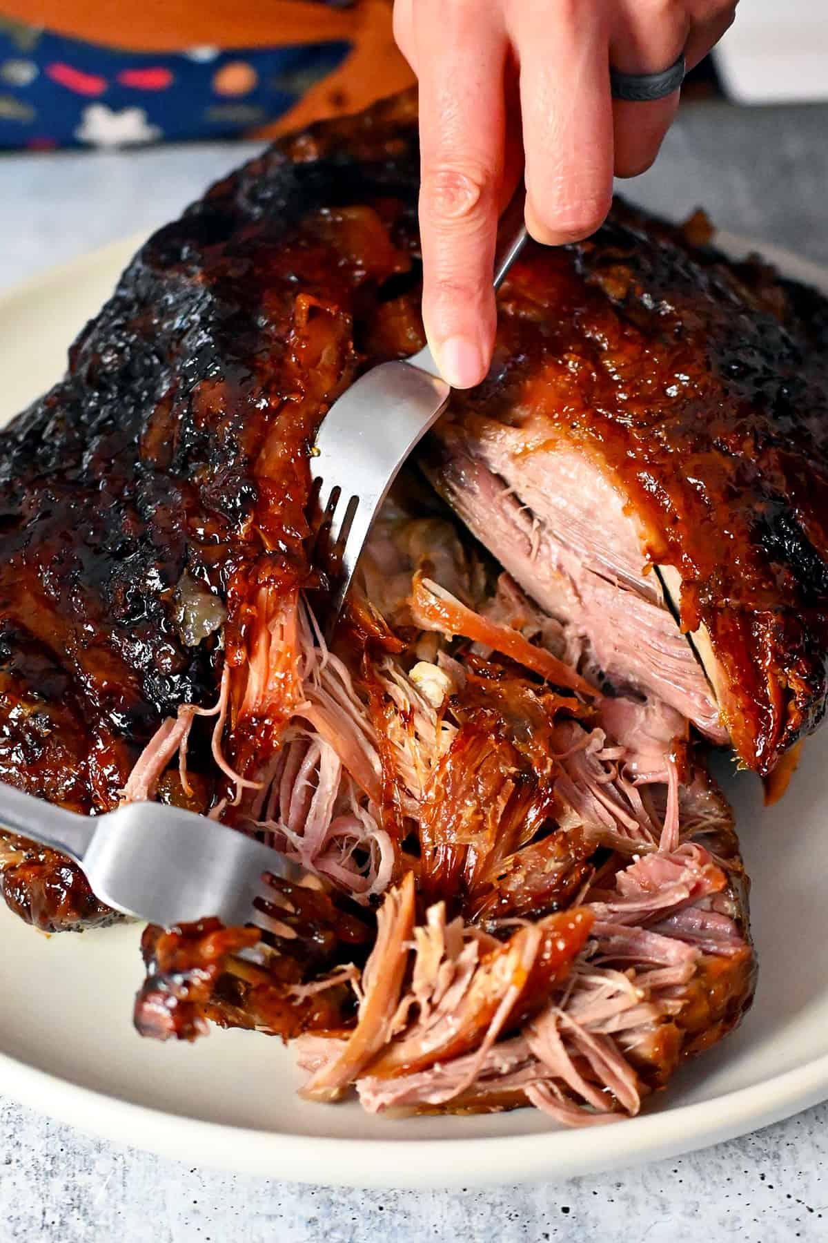 pulled pork being glazed with a brush